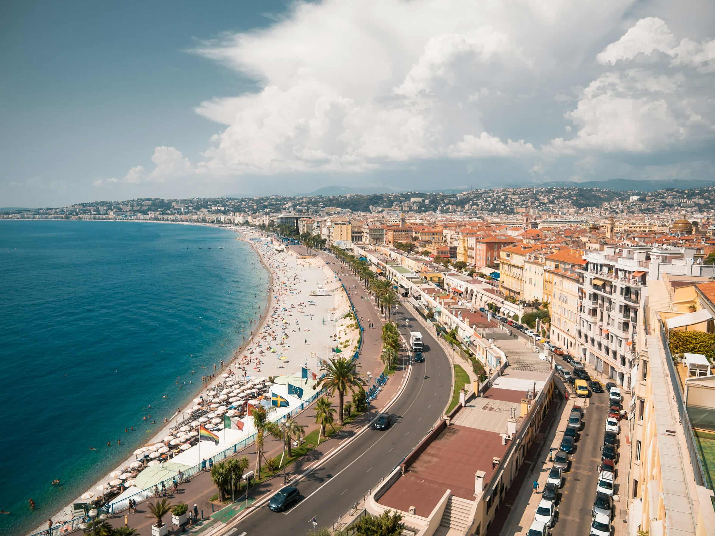Le rivage de Nice vu d’un point haut, l’avenue du littoral longeant la plage et les immeubles alignés jusqu’à la pointe